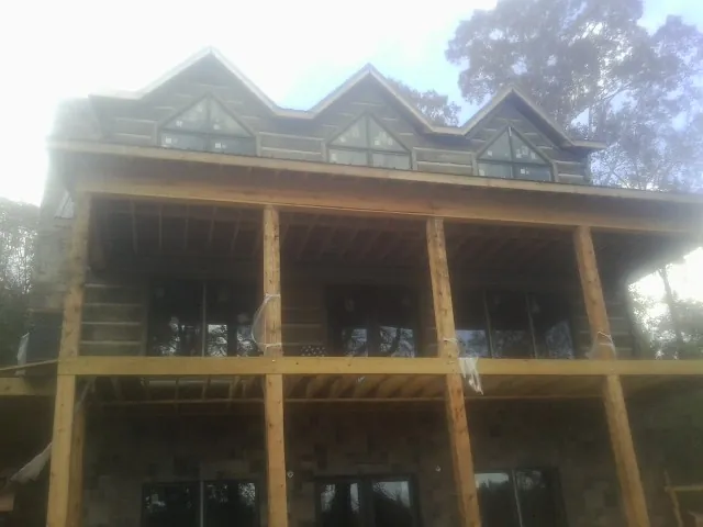 Dormers and porch framing on a large log home under construction — Roof Coating work by our crew in Enon Valley