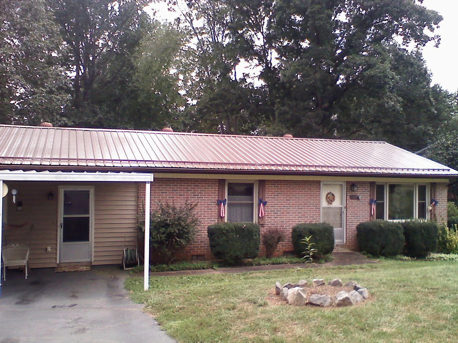 Bronze metal roof and carport on a brick ranch home — Roof Repair work by our crew in Enon Valley